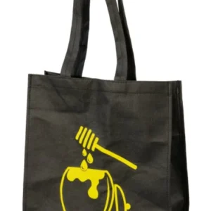 Svart bärkasse med gult tryck av en honungskruka och droppande honung.