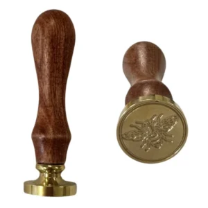 Sigillstämpel i mässing med trähandtag och ingraverat bimotiv, perfekt för dekoration och honungsburkar.