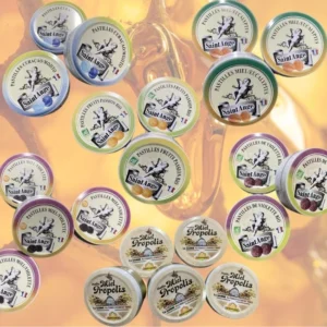 Plåtburkar med bonbons saint ange karameller i olika smaker, placerade på träyta.