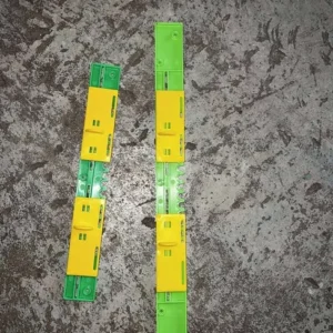 Två justerbara flusterskydd i grön och gul plast för bikupor, visade ovanifrån mot grå bakgrund.