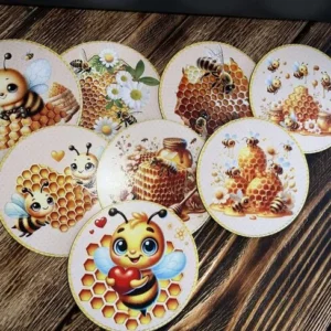 Åtta runda träunderlägg med olika motiv av bin, honung och bikakor, utlagda på träbord.